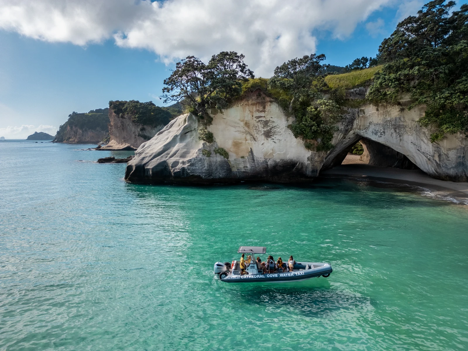 Water taxi in the turquoise water at Cathedral Cove