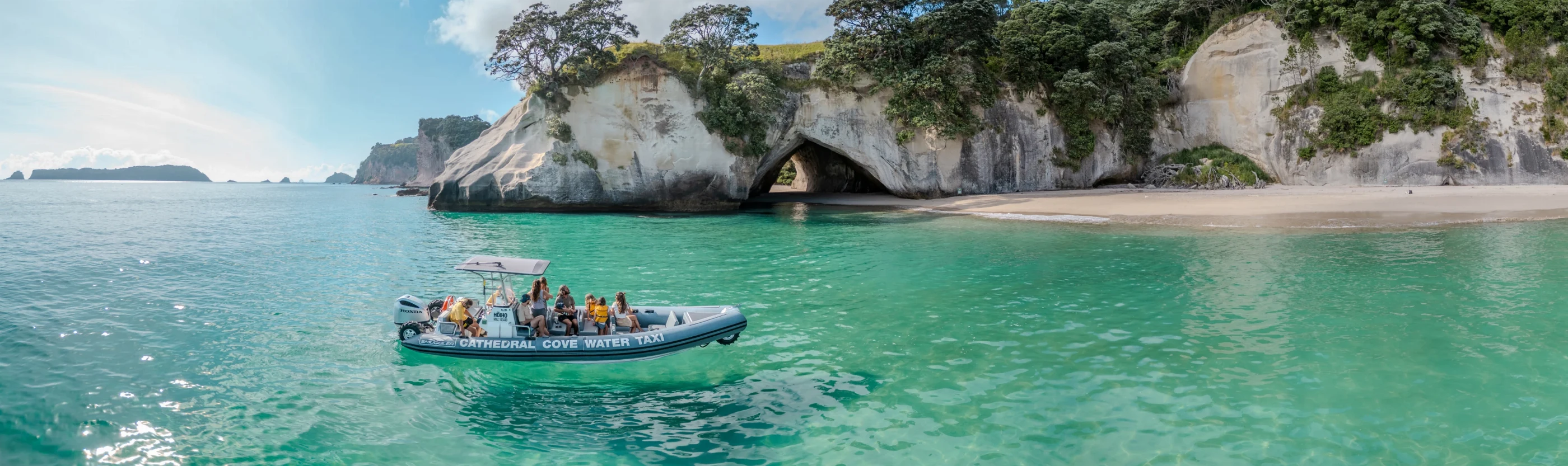 Water taxi cruising past Cathedral Cove